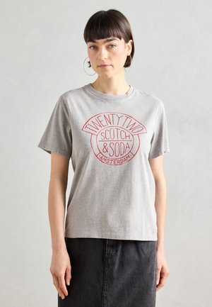 T-shirt in cotone grigio con maniche corte. Presenta un logo circolare rosso con il testo "TWENTY TWO SCOTCH & SODA AMSTERDAM" al centro.