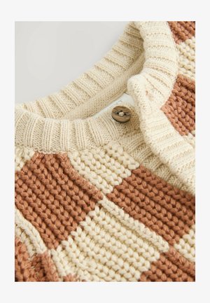 adīts džemperis ar maiņojošām krēma un terakotas kvadrātiņu rakstām, ribotu apkakli un brūnu pogu akcentu.