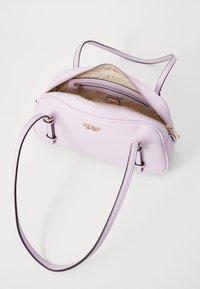 Bolso estructurado de color púrpura claro hecho de cuero suave, con herrajes en tono dorado, cierre de cremallera y una sola correa para el hombro.