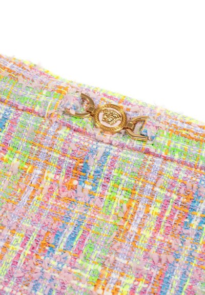 Tessuto in tweed multicolore con fili pastello, presenta una chiusura decorativa in oro con un emblema dettagliato di testa di leone.