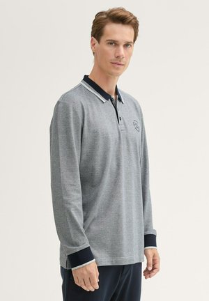 Gray long-sleeve polo with a navy collar, button placket, and embroidered logo on the chest. Features ribbed cuffs with navy trim.