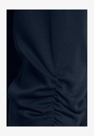 Tumesinist kudumit, mis on tihedalt horisontaalselt voltidega kokku kogutud, luues tekstuurseid voltide ja kortsudega pindu.