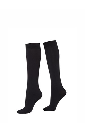 Paar schlichte schwarze Kniestrümpfe vor weißem Hintergrund.