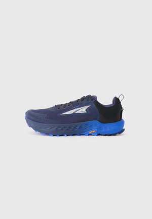 Baskets de sport bleu marine et noires avec semelle épaisse bleue, semelage texturé, logo réfléchissant, lacets noirs et une languette au talon.