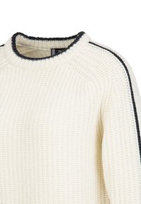 Cremfarbener Pullover mit strukturiertem Muster, der einen schwarzen Akzent an den Schultern und einen runden Halsausschnitt aufweist. Mittellange Ärmel.