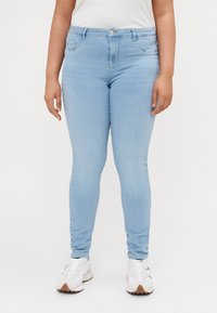 Light blue, slim-fit jeans with a mid-rise waist, a single button closure, and front pockets, made from denim fabric.