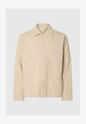 Beige corduroy shirt jacket with long sleeves, two chest pockets, button front, and classic collar on light grey background.