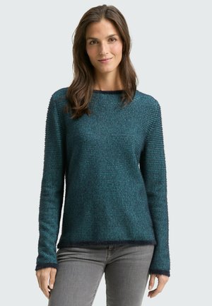 Pull en tricot teal avec une surface texturée, des manches longues et un col rond. Présente un ourlet et des poignets plus foncés pour le contraste.
