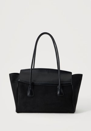 Schwarze Leder-Tote-Handtasche mit langen Griffen und einem strukturierten, breiten Boden auf schlichtem hellem Hintergrund.