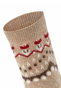 Calza a maglia beige con disegni geometrici in rosso, bianco e marrone. Cuffia rigata, texture morbida con motivi festivi.