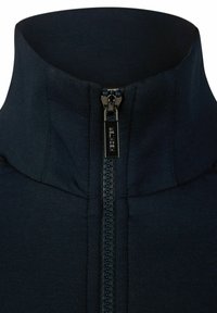 Marine blauwe half-zip pullover met hoge kraag, geribbelde textuur en gladde ritsdetails. Gemaakt van zachte, rekbare stof voor comfort.