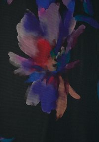 Tessuto nero con un vivace motivo floreale caratterizzato da grandi fiori viola, rossi e turchesi, che mostra una texture liscia.