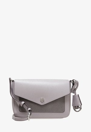 Petit sac bandoulière gris clair avec finition texturée, fermeture à rabat, sangle réglable et breloque ronde en métal avec logo sur le côté.