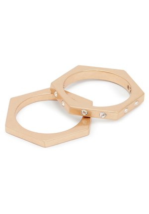 Gold-tone metal hexagonal rings with a smooth finish, featuring five small embedded clear crystals on one band.