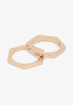 Bandeaux hexagonaux en métal doré, avec une finition lisse, ornés de cinq petits cristaux transparents incrustés sur une des bandes.