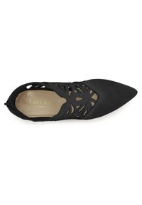 Zapato negro de punta afilada con un patrón floral en corte, parte superior de tela suave y plantilla beige con letras doradas.
