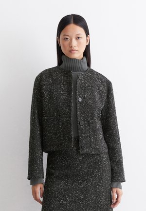 Gekürzte Jacke aus dunklem, strukturiertem Stoff mit Fischgrätenmuster, mit rundem Ausschnitt, zwei frontalen Taschen und Knopfverschlüssen.