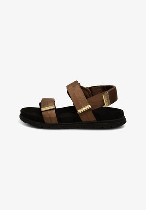 Brown fabric sandals with two adjustable straps, gold accents, a black cushioned sole, and textured detailing on the straps.