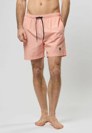 Leichte, gestreifte Badeshorts in Koralle und Weiß. Mit einem elastischen Bund und einem marineblauen Kordelzug sowie einem kleinen Logoakzent.