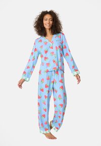 Blaue Schlafanzugset mit roten Erdbeer-Drucken und grünen Akzenten an den Bündchen. Langärmliges Oberteil und locker sitzende Hose aus weichem Stoff.