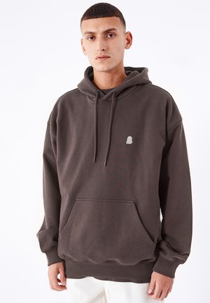 Mörkgrå hoodie i mjukt bomullsblandning, med en framficka i känguru-stil, dragsko på huvan och liten logotyp på bröstet.