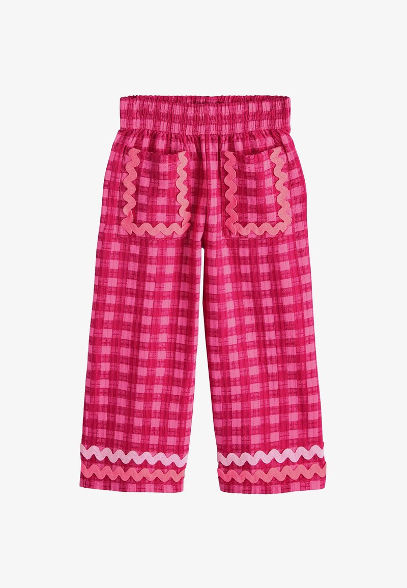 Pantalon rose à carreaux avec taille élastique, deux poches avant bordées d'un galon ondulé, et galon ondulé assorti près de l'ourlet.