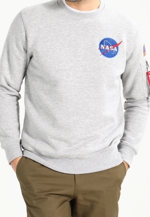 Felpa grigia con logo NASA e dettagli rossi, scollo rotondo, polsini e orlo a costine, con tasca utility sulla manica sinistra.