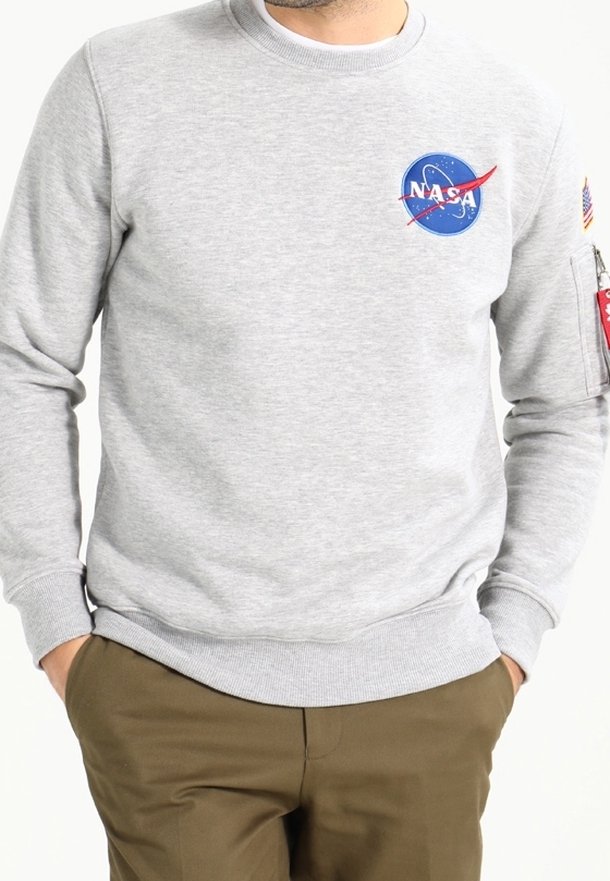 Felpa grigia con logo NASA e dettagli rossi, scollo rotondo, polsini e orlo a costine, con tasca utility sulla manica sinistra.