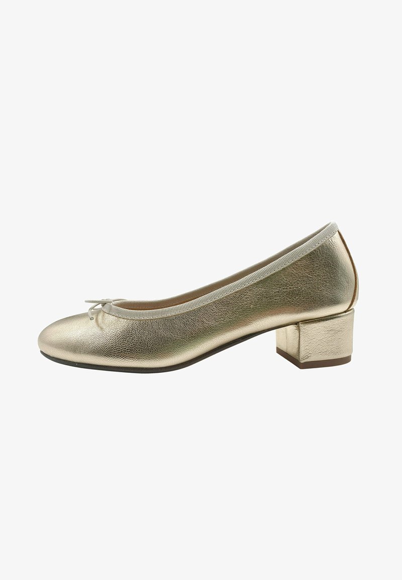 Ballet flat metallico dorato con punta tonda, tacco a blocco piccolo e sottile fiocco decorativo sulla parte anteriore. La superficie testurizzata riflette la luce.