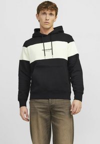 Sort hoodie med hvide vandrette striber. Har snoretræk, en lommesæk foran og logo-tekst i midten. Blødt materiale af bomuldsblanding.