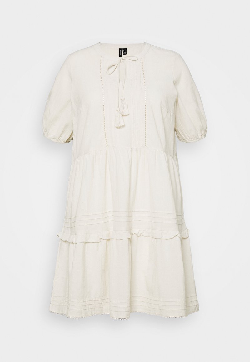 Robe blanche en coton avec des manches bouffantes, un col rond, un lien à pompons et un ourlet à volants en étages. Présentant des détails texturés subtils et un design à plis.