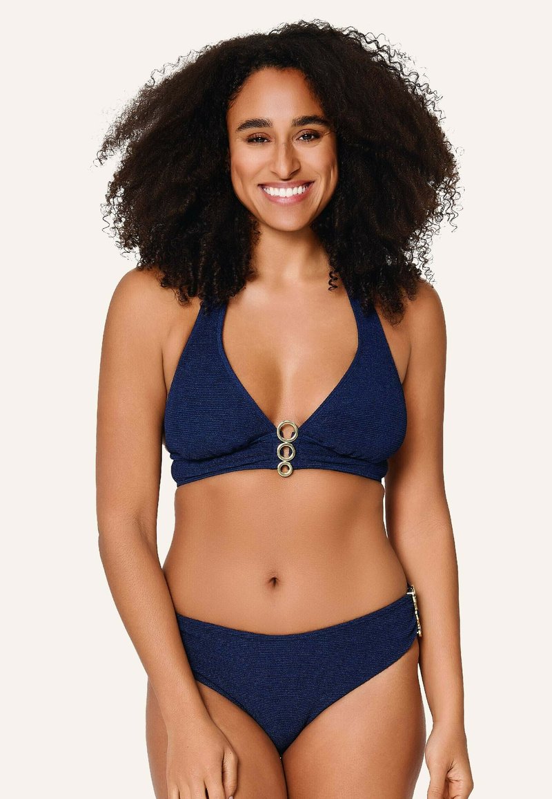 Námořnický modrý bikinový top s designem za krk, vybavený třemi kovovými kroužky ve středu; odpovídající bikiny s kovovými akcenty na stranách.