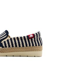 Scarpa slip-on a strisce navy e crema con suola in juta intrecciata, caratterizzata da un'etichetta rossa e un design a punta arrotondata.