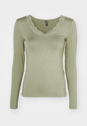 Long-sleeve top in soft olive green fabric, featuring a lace-trimmed V-neckline and a fitted design with clean hem and cuffs.
