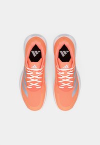 Πορτοκαλί αθλητικά παπούτσια με επάνω μέρος από δίχτυ, λευκά κορδόνια και ασημί ρίγες. Διαθέτουν μαλακή σόλα και επενδυμένο γιακά για άνεση.