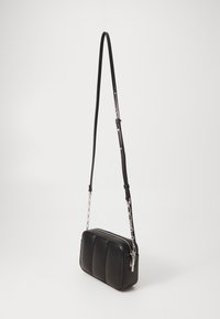 Černá crossbody taška s hladkým koženým povrchem, obdélníkovým tvarem, prošívaným vzorem na přední straně a odnímatelným řetízkovým popruhem.