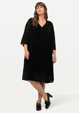 Schwarzes Samtkleid mit floraler Spitze, V-Ausschnitt, Dreiviertelärmeln und lockerer Passform, ausgestattet mit Seitentaschen und Falten.