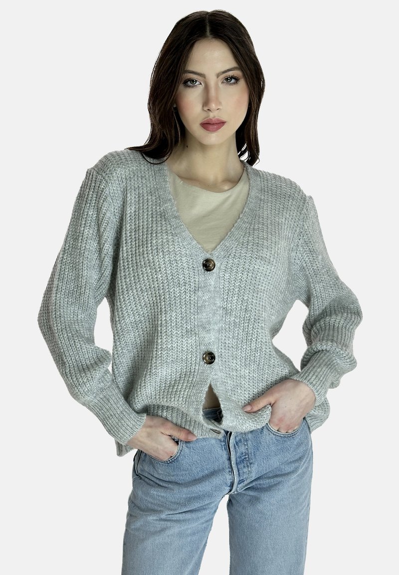 Grauer Strickcardigan mit V-Ausschnitt, verfügt über einen Knopfverschluss und gerippte Bündchen. Wird über einem hellen Oberteil getragen und mit blauen Jeans kombiniert.