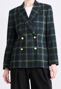 Veste croisée en tartan bleu marine avec des accents verts et jaunes. Dotée de boutons dorés, de revers nets et d'une coupe décontractée.