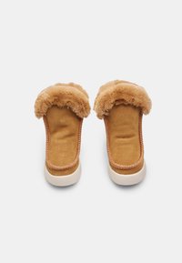 Calzature slip-on color beige con un morbido colletto in finta pelliccia, tomaia in suede, cuciture a contrasto e suola in gomma bianca.