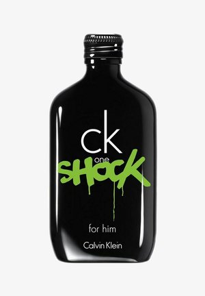 Musta lasipullo pyöristettynä, jossa on rohkeaa vihreää graffitityylistä tekstiä. Etiketissä lukee "ck one SHOCK for him" ja "Calvin Klein."