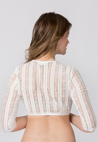 Weißes Spitzen-Crop-Top mit transparentem Design, das vertikale gestreifte Muster und lange Ärmel aufweist. Knopfverschluss im Rücken.