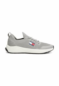 Scarpa atletica grigia con tomaia in maglia, colletto elastico e patch logo prominente. Presenta una suola intermedia bianca e suola in gomma nera.