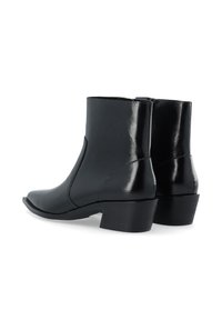 Schwarze Lederstiefeletten mit glänzender Oberfläche, abgerundeter Zehenform, niedrigem quadratischen Absatz und minimalistischer Steppnaht.