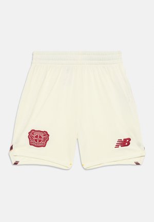 Cremfarbene Sportshorts mit elastischem Taillenbund, seitlichen Schlitzen, rot gesticktem Bayer Leverkusen-Logo und New Balance-Branding.