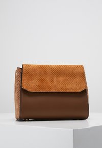 Brązowa skórzana torba z perforowaną klapą z jasnego zamszu, prostokątny kształt i gładka tekstura. Posiada kontrastowe materiały i proste okucia.