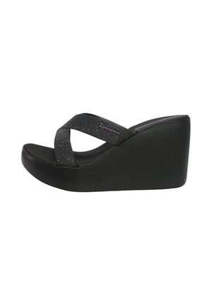 Sandali wedge neri con design a bande incrociate, realizzati in materiale testurizzato con glitter argento, presentano una suola robusta e spessa.