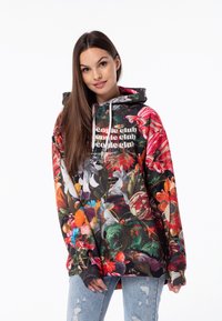 Hooded majica s vibrantnim cvjetnim uzorkom, koja se sastoji od mješavine boja, primjetnih grafika i opuštenog kroja. Mekana tkanina, dugi rukavi.