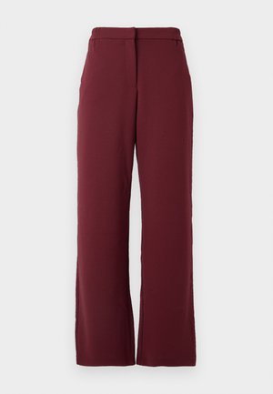 Naisten sirge jalgadega püksid tumepunases toones, kõrge vöökohaga ja külgtaskutega, esitlemine halli valge tausta ees.