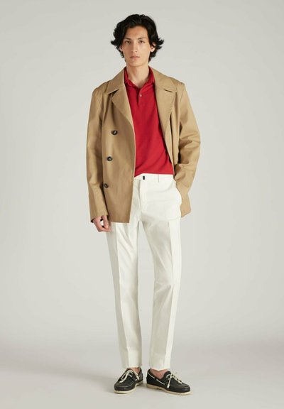 Beige dubbelzijdig jasje, rode polo-shirt, witte op maat gemaakte broek, en zwarte schoenen met beige veters. Eenvoudig ontwerp met een schone silhouet.